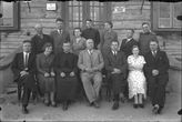 Grupė žmonių su kunigu prie Krekenavos pradžios mokyklos durų