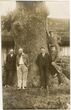 E. Šalkauskas su keturiais vyrais prie storo medžio kamieno
