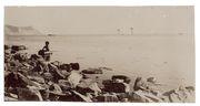 Fotografija „Akmenuotas jūros krantas ir sėdintis berniukas“