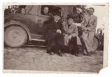 Kunigas Stanislovas Mažeika su trim vyrais prie automobilio