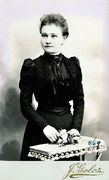 Stovinčios moters su gėlių puokštele rankose portretas